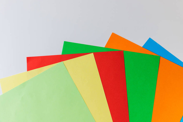 Patrón de papel multicolor presentado en forma de rayos uno tras otro sobre un fondo blanco
 - Foto, imagen