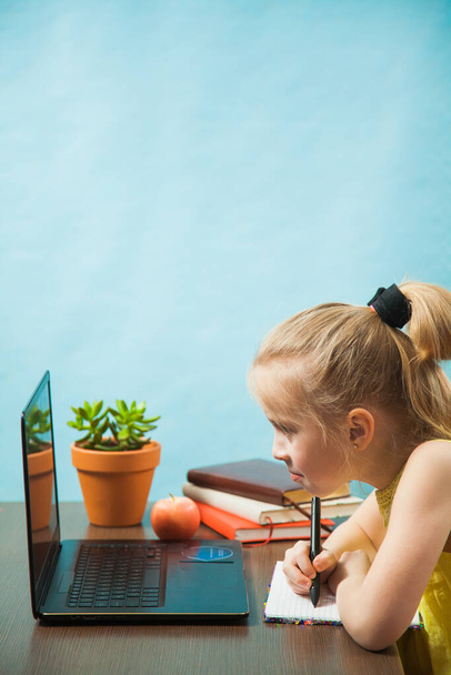 Feliz estudiante de primaria niña educación en el hogar en el ordenador portátil en línea por Internet
. - Foto, imagen