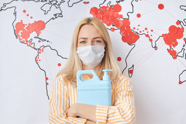 stop spreading coronavirus. woman in medical mask, world map with red marks in the background - Foto, Imagem