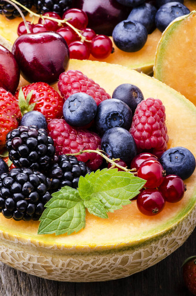 tuoreita hedelmiä salaatti meloni täynnä marjoja ja kirsikoita maalaismainen puu tausta
 - Valokuva, kuva