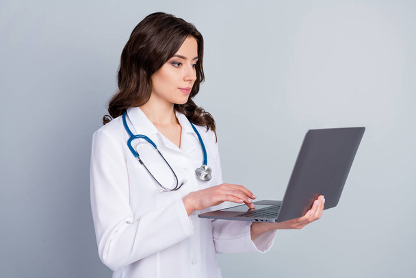 Photo of focused experienced doc girl have corona virus patient pneumonia disease use laptop online best world doc communication workshop wear white uniform isolated gray color background - Fotoğraf, Görsel