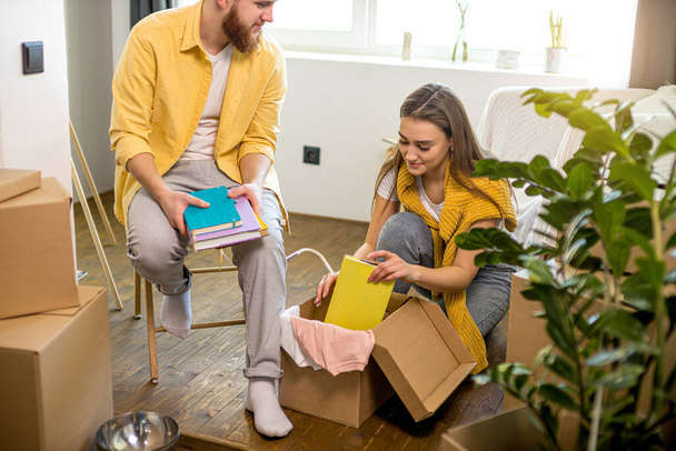 young caucasian couple unpack cardboard box at home - Photo, image