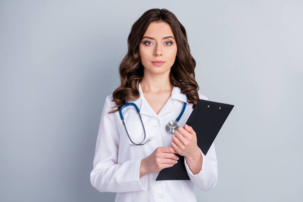 Close-up portrait of her she nice attractive lovely content wavy-haired girl doc holding in hands medical insurance assistance terms diagnostic isolated over grey pastel color background - Foto, Imagem