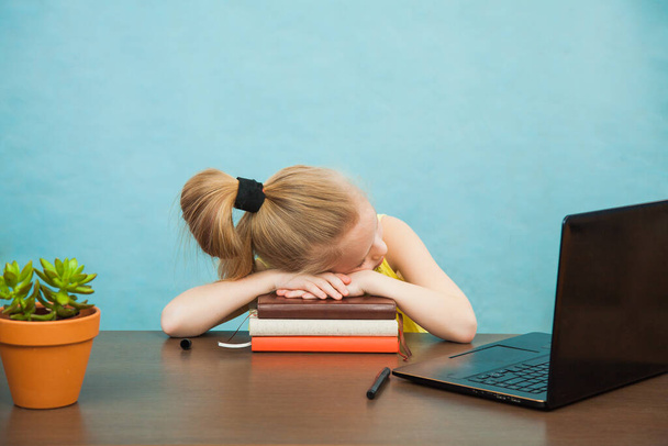 Little primary school girl in antiviral mask sleep near laptop home isolation. - Photo, Image