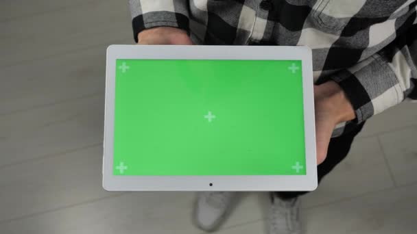 Adam ofiste duruyor ve elinde yeşil ekran krom anahtarıyla dijital tablet tutuyor. - Video, Çekim