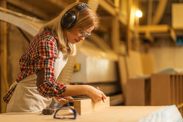 hardworking carpenter woman at workplace - Foto, afbeelding