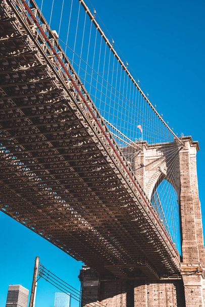 Brooklyn Bridge über den East River von New York City Lower Manhattan Waterfront am Morgen gesehen. - Foto, Bild