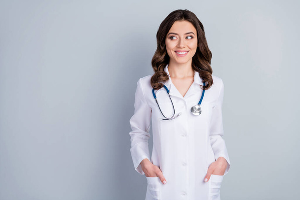 Photo of attractive family doc experienced lady consultant assistant virology clinic look side empty space beaming smile wear white lab coat stethoscope isolated grey color background - Φωτογραφία, εικόνα