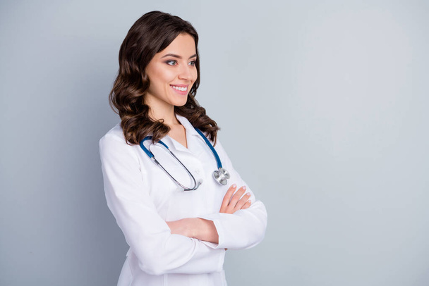 Profile photo of beautiful family doc lady patients consultation beaming smiling virology clinic arms crossed look empty space wear lab coat stethoscope isolated grey color background - Foto, afbeelding