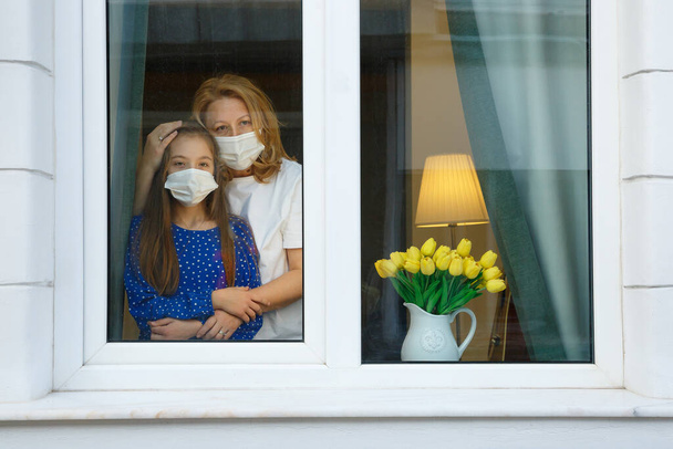 Mother and Daughter looking out for the quarantine to finish as soon as possible - Photo, Image