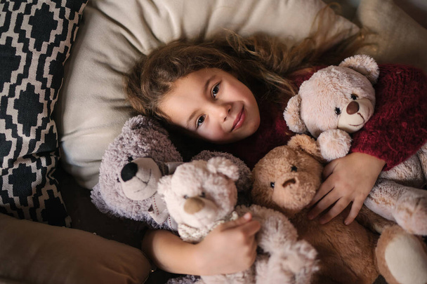 portrait of a smiling little girl with teddy bear toys - Фото, зображення