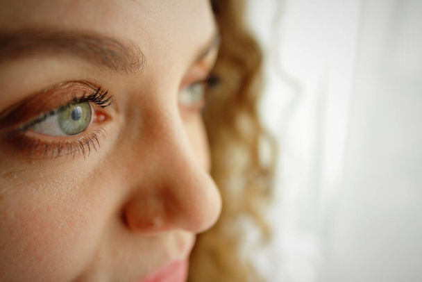 eyes close up of a beautiful curly girl on a light background - Fotoğraf, Görsel