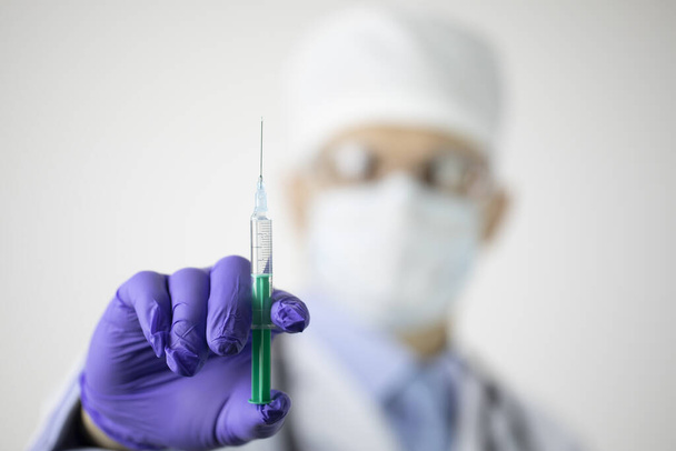 Doctor holding syringe with vaccine against coronavirus on white background - Foto, Imagem