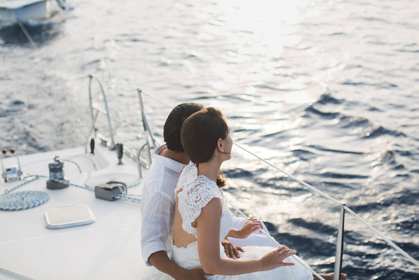 Wedding couple is hugging on a yacht. Beauty bride with groom. - Foto, afbeelding