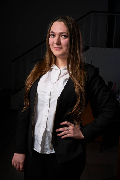 Closeup portrait of a young business woman, happy, cheerful, handsome businessman is standing in a modern office in a white blouse - Fotografie, Obrázek