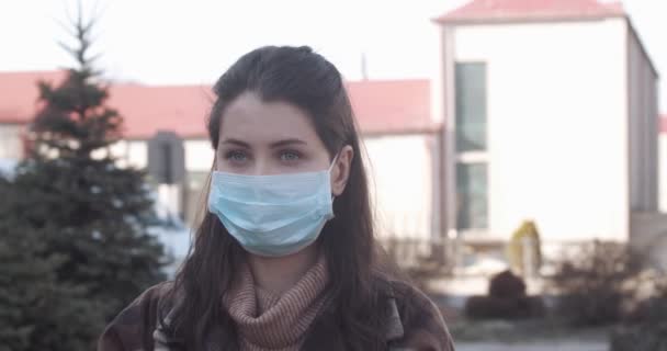 Sokakta koruyucu maske takmış genç bir kadının portresi. - Video, Çekim