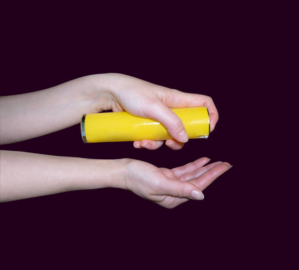Las manos femeninas sostienen una crema, antiséptico, primer plano, fondo rosa
. - Foto, imagen