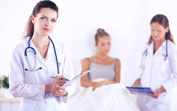 Woman doctor with folder standing at hospital - Photo, Image