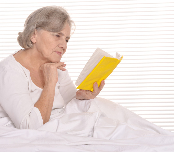 older woman resting in the bedroom - Фото, изображение