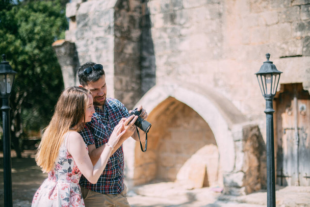Les amoureux prennent des photos des attractions près du mur de pierre du temple. Quelques jeunes mariés admirent l'ancienne église. Lune de miel en voyage
 - Photo, image