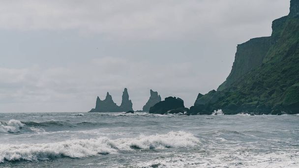 Reynisfjaran musta hiekkaranta kalliomuodostelmilla meressä, Vikin etelärannikko, Islanti
 - Valokuva, kuva