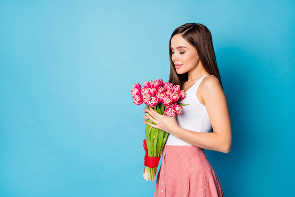 Profile side photo of charming lovely cute girl smell fresh natural 8-march gift tulips wear tank-top isolated over blue color background - Photo, Image
