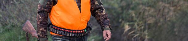 Silahlı bir avcı ve bir köpek bozkırda ilk kara çıkarlar yansıtıcı yelek giymiş sülün avlarlar. - Fotoğraf, Görsel