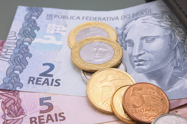 Βραζιλιάνικο χρήμα, νόμισμα της Βραζιλίας, πραγματικό, Reais, διάφορα χαρτονομίσματα και κέρματα, γκρο πλαν σε σκούρο φόντο. Χρήματα σε μετρητά - Φωτογραφία, εικόνα