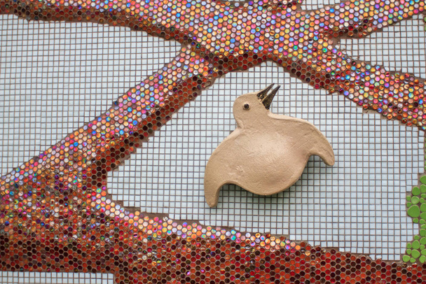 Egy madár mozaikcsíkos képe a falon egy nyilvános parkban - Fotó, kép