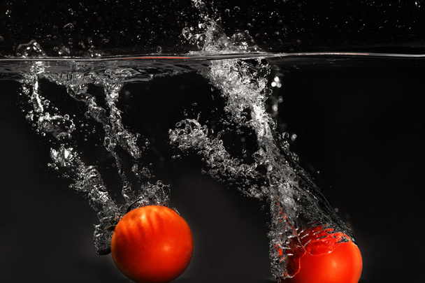 Fresh tomato dropped into water - Фото, зображення
