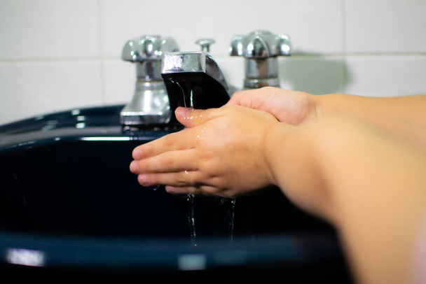 ständiges Händewaschen mit viel Seife und Wasser, um die Ausbreitung von Covid 19 zu verhindern - Foto, Bild