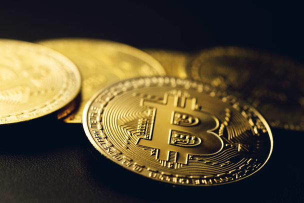Golden colored bitcoin coins on a black background with high contrast. - Zdjęcie, obraz