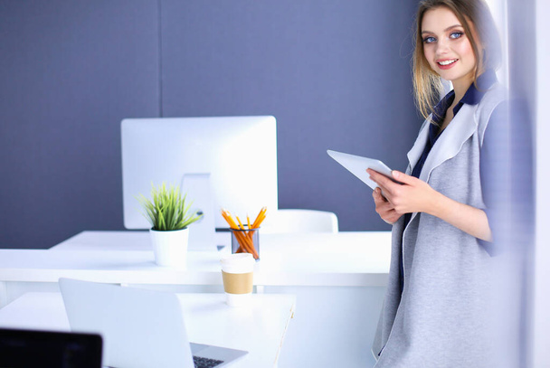 Young businesswoman standing in front of a table in the office - Fotoğraf, Görsel