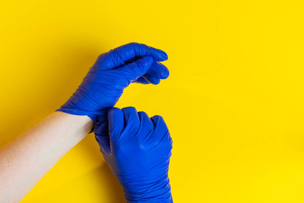 A woman takes off his blue latex gloves. Quarantine End - Zdjęcie, obraz
