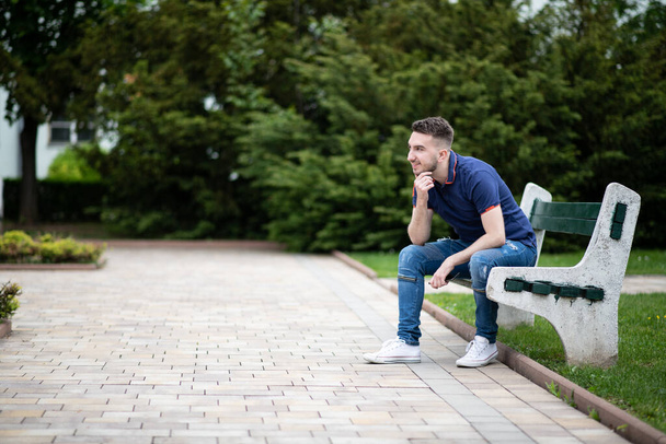 Portrait of a Confident and Successful Young Man With Blue Shirt Outside in Park Sitting on Bench - Fotografie, Obrázek