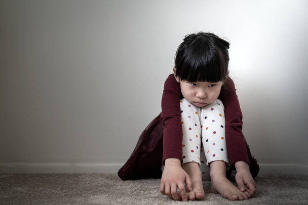 Μοναχικό θλιμμένο κοριτσάκι που κρατάει τα γόνατά της - Φωτογραφία, εικόνα