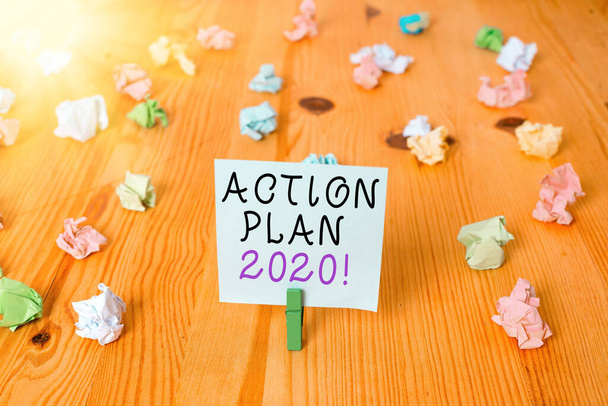 Почерк текста Action Plan 2020. Концепция подразумевает предлагаемую стратегию или ход действий на текущий год Цветные скомканные бумаги пустое напоминание деревянный пол подложка
. - Фото, изображение