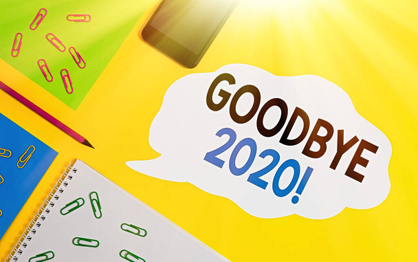La escritura a mano conceptual que muestra Good Bye 2020. Foto de negocios que muestra expresan buenos deseos al despedirse o al final del año pasado. Hojas mensaje lápiz teléfono inteligente de color liso fondo
. - Foto, Imagen