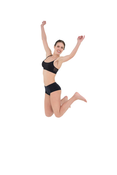 Sporty young woman jumping isolated on white background - Fotó, kép