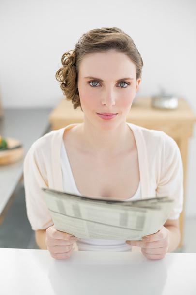Young pretty woman holding newspaper in her kitchen holding newspaper - Φωτογραφία, εικόνα