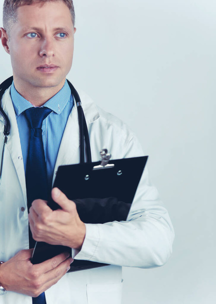 Male doctor standing with folder, isolated on white background - Valokuva, kuva