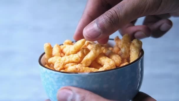 hands of young man take chips from bowl - Filmati, video