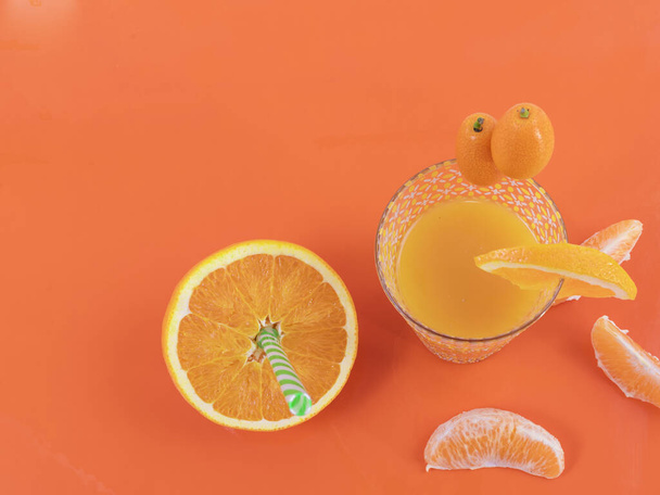 Χυμός πορτοκαλιού, μικρά πορτοκάλια και πορτοκάλια σε φέτες σε φόντο πορτοκαλιού - Διατροφικό και νόστιμο πορτοκάλι - Φωτογραφία, εικόνα