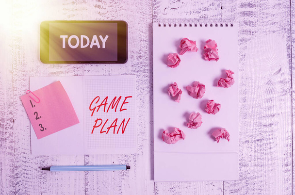 Word writing text Game Plan. Business concept for strategy worked out in advance in sport politics or business Squared spiral notebook marker smartphone paper balls note clip wooden. - Photo, Image