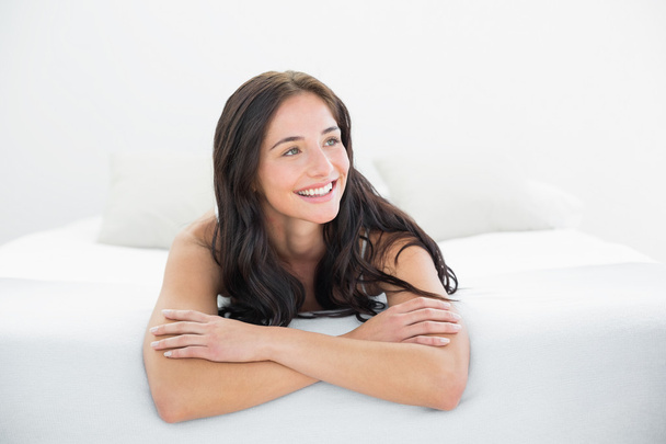 Smiling woman looking away in bed - Foto, Imagem