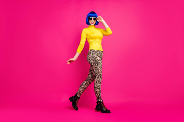 Full length profile photo of cheerful lady walk street trend traveler wear specs yellow turtleneck blue short wig boots leopard pants isolated bright pink color background - Foto, Imagem