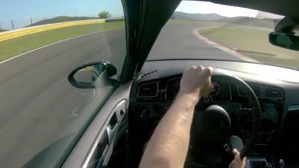 CLOSE UP: Man genieten van een zonnige dag door het besturen van zijn sportscar langs gesloten circuit. - Video
