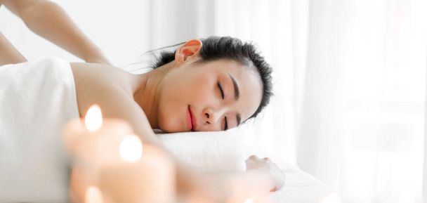 Sonriente de joven hermosa mujer asiática limpia fresca sana piel blanca tratamiento de spa relajante tumbado en la toalla en el salón de masajes y spa - Foto, imagen