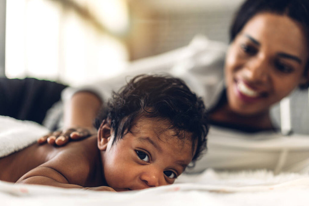 Portret cieszyć się szczęśliwą miłością rodziny afrykańskiej amerykańskiej matki bawiącej się z uroczym małym afrykańskim dzieckiem amerykańskim.Mama dotykając słodkie chwile syna dobry czas w białej sypialni.Love koncepcji rodziny czarnych - Zdjęcie, obraz