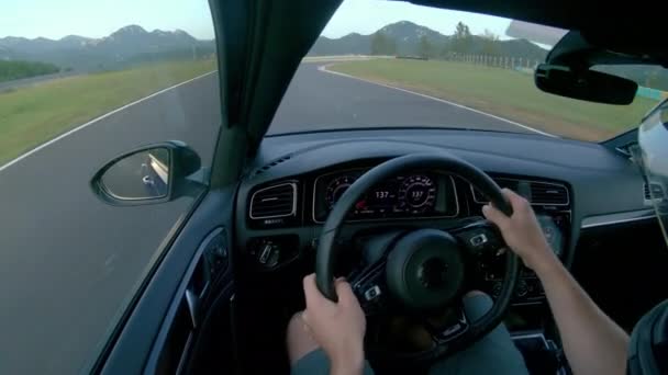 CLOSE UP: Man wearing a helmet races his fast car along the fun racetrack. - Footage, Video